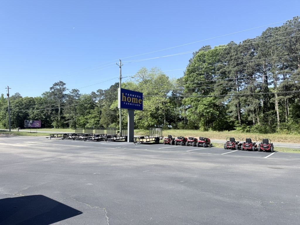 Mowers and trailer equipment lined up outside a store entrance.