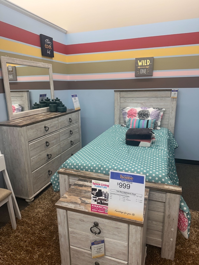 A child's bedroom display with painted stripes and 'Wild One' sign.