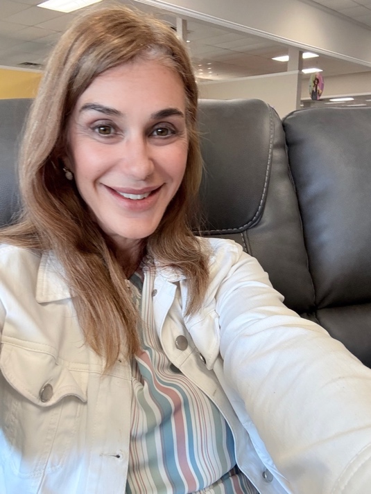 A PETERMAYER team member seated in a recliner on the showroom floor.